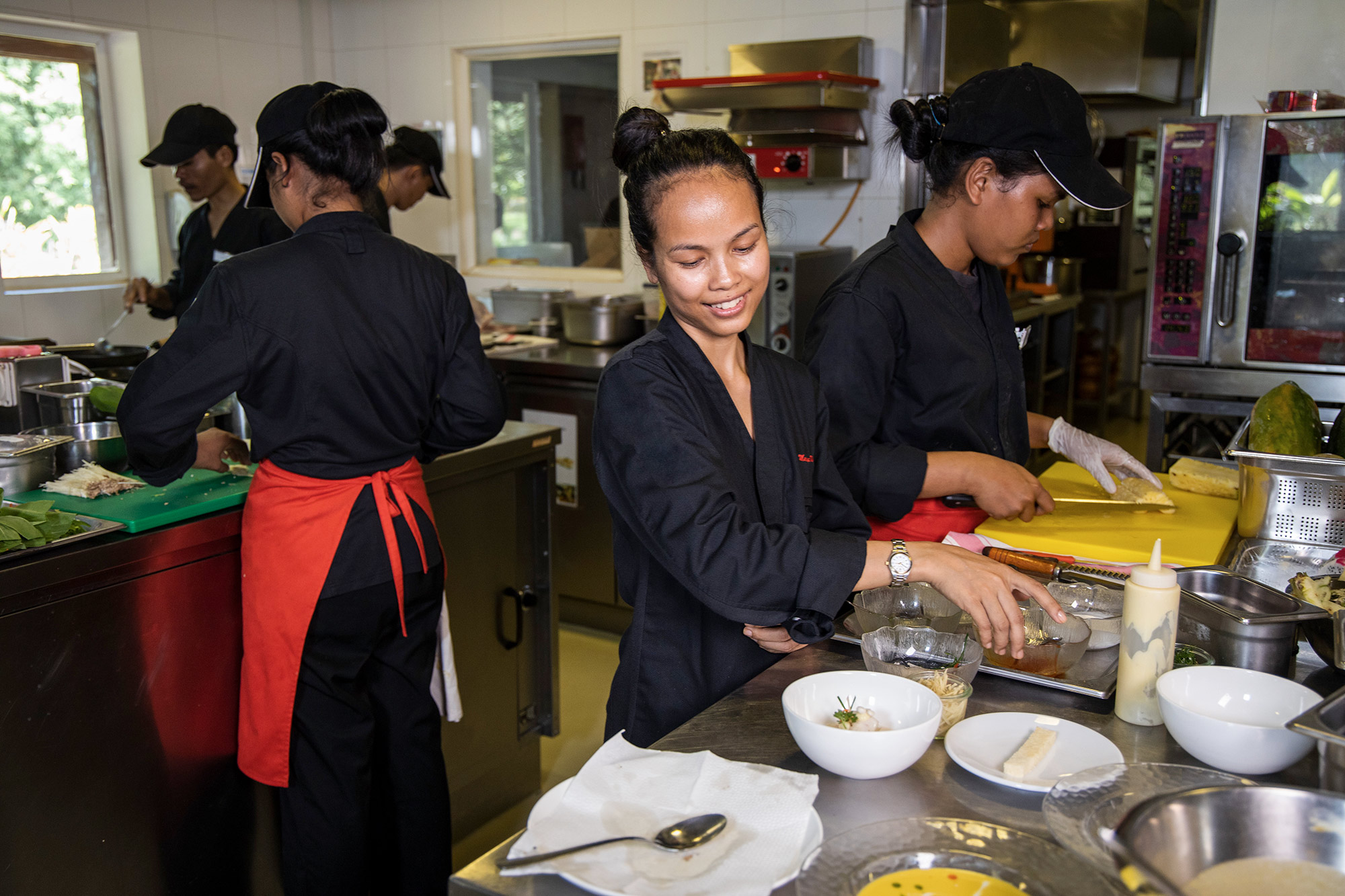 Mariya Un Noun prépare des plats avec son équipe en cuisine.