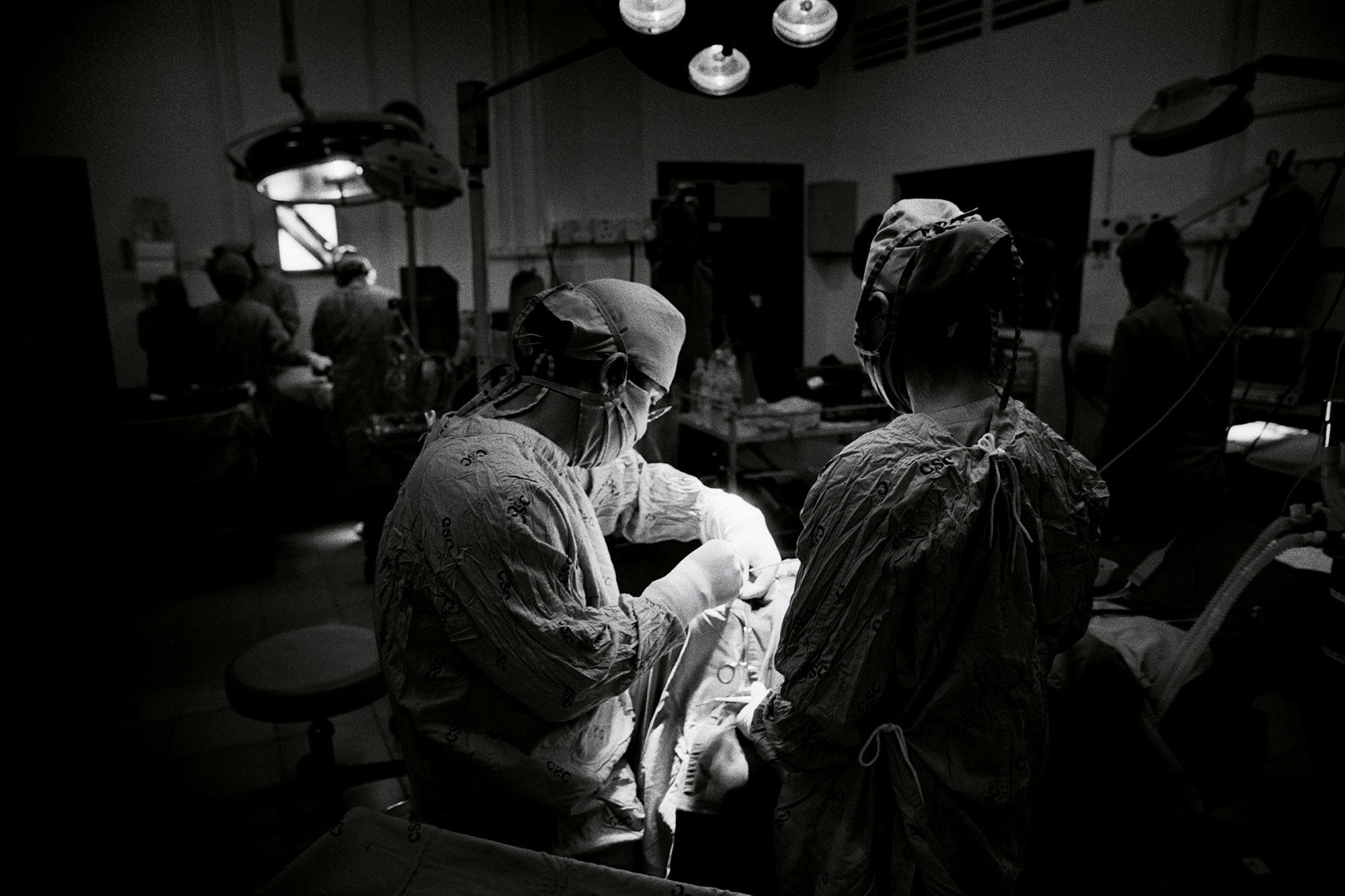 Photographie en noir et blanc d’une équipe médicale lors d’une opération.