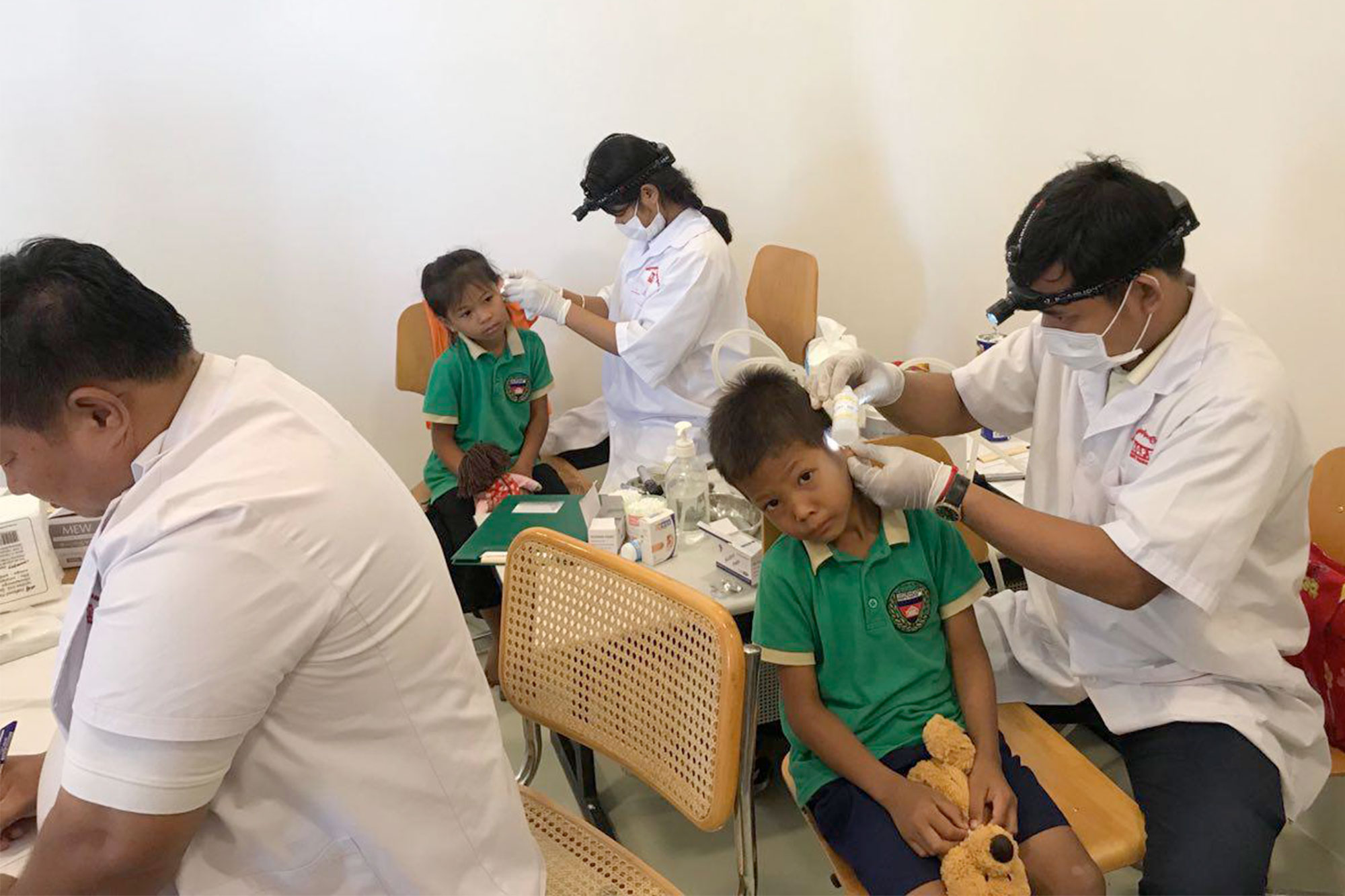Une équipe médicale examine des enfants dans une salle de soins.