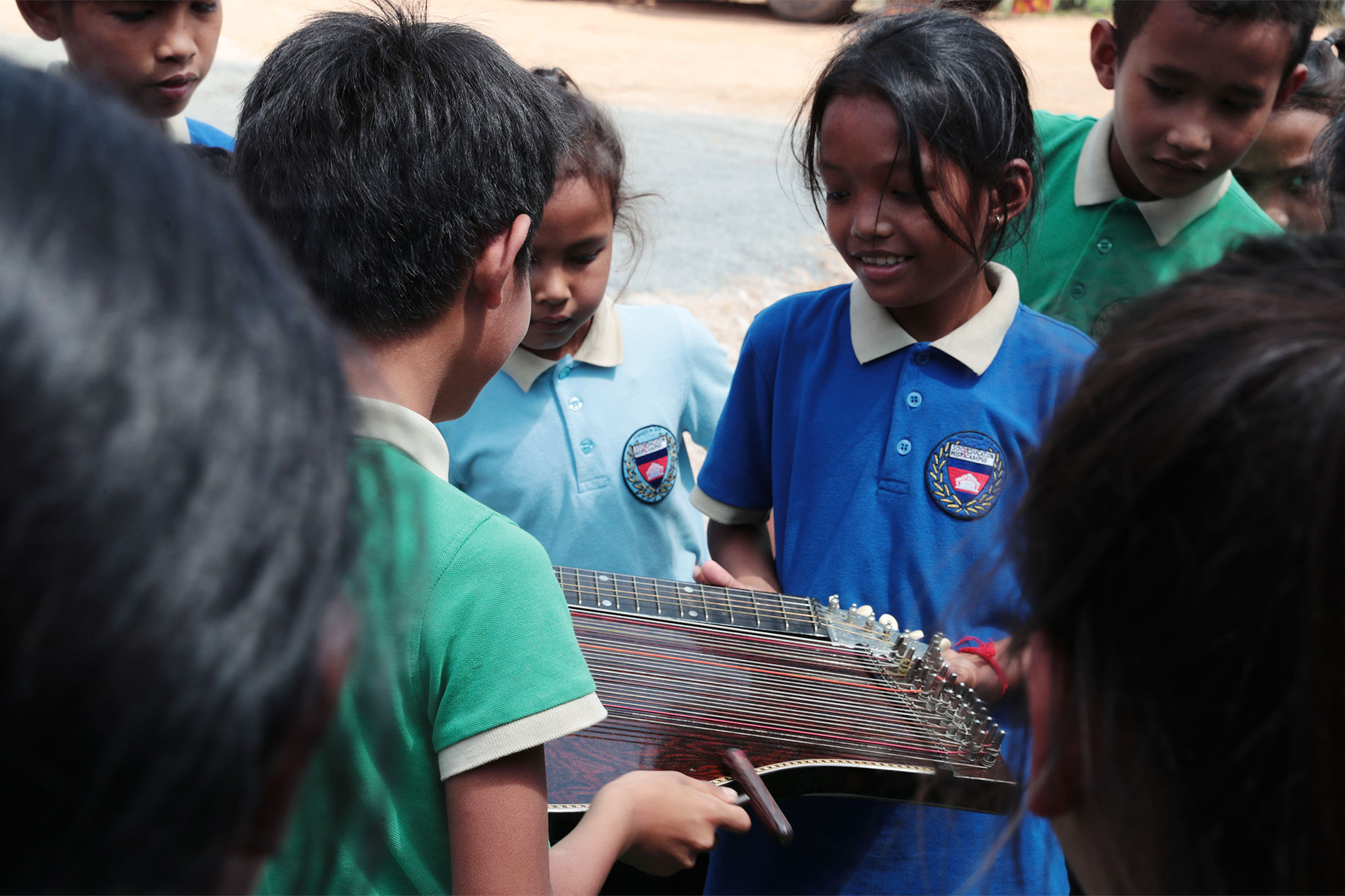 Des enfants découvrent ensemble un instrument à cordes.