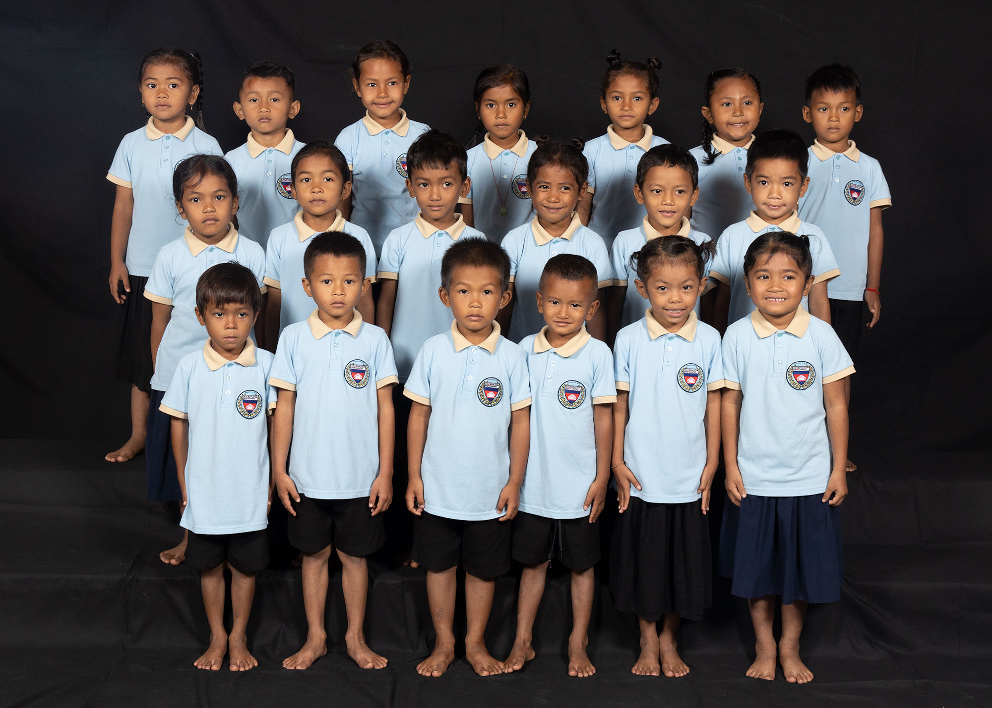 Portrait de groupe d’enfants en uniformes scolaires bleu clair.