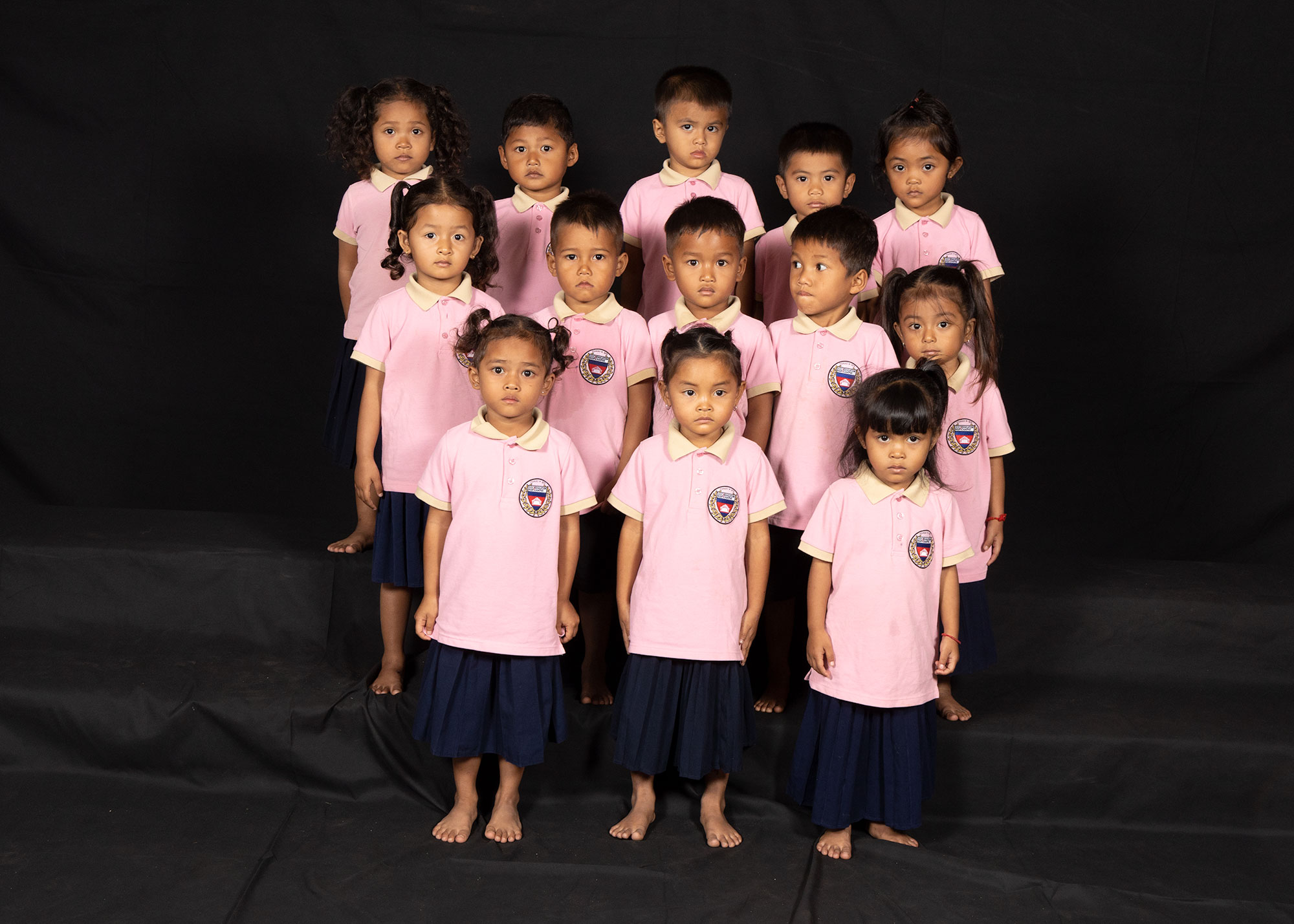 Portrait de groupe d’enfants en uniformes scolaires roses.