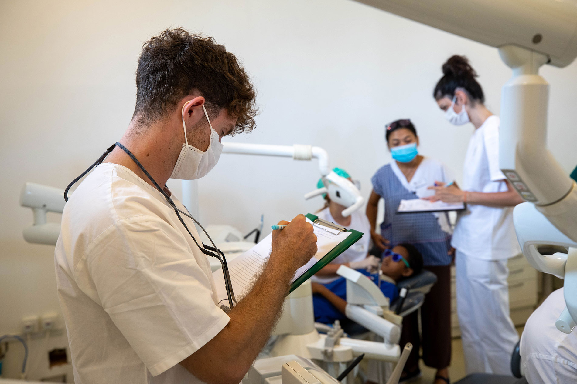 Un dentiste note les résultats d’un examen à la clinique.