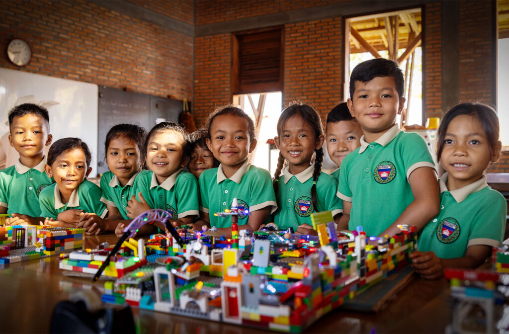 Schulkinder präsentieren ihre bunte LEGO-Stadt.