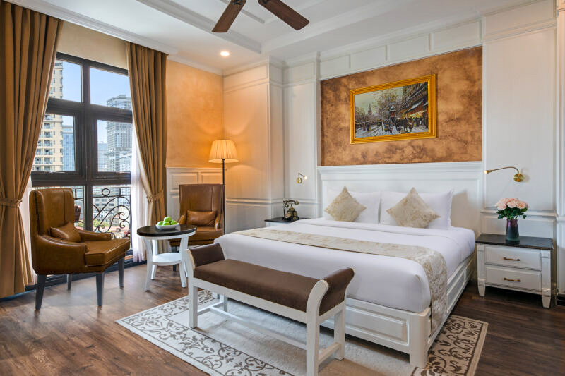 Hotel room with a double bed and large windows.