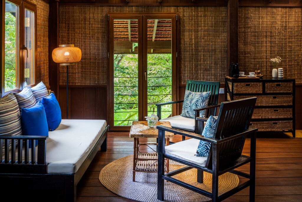 Seating area with a sofa in a wooden bungalow at Farmhouse Resort.