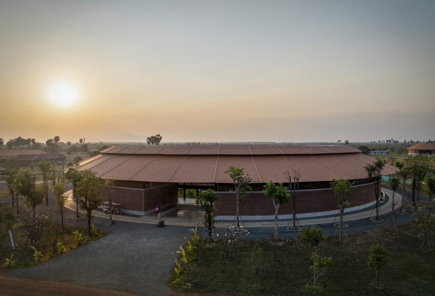 The new circular school building in low sunlight.