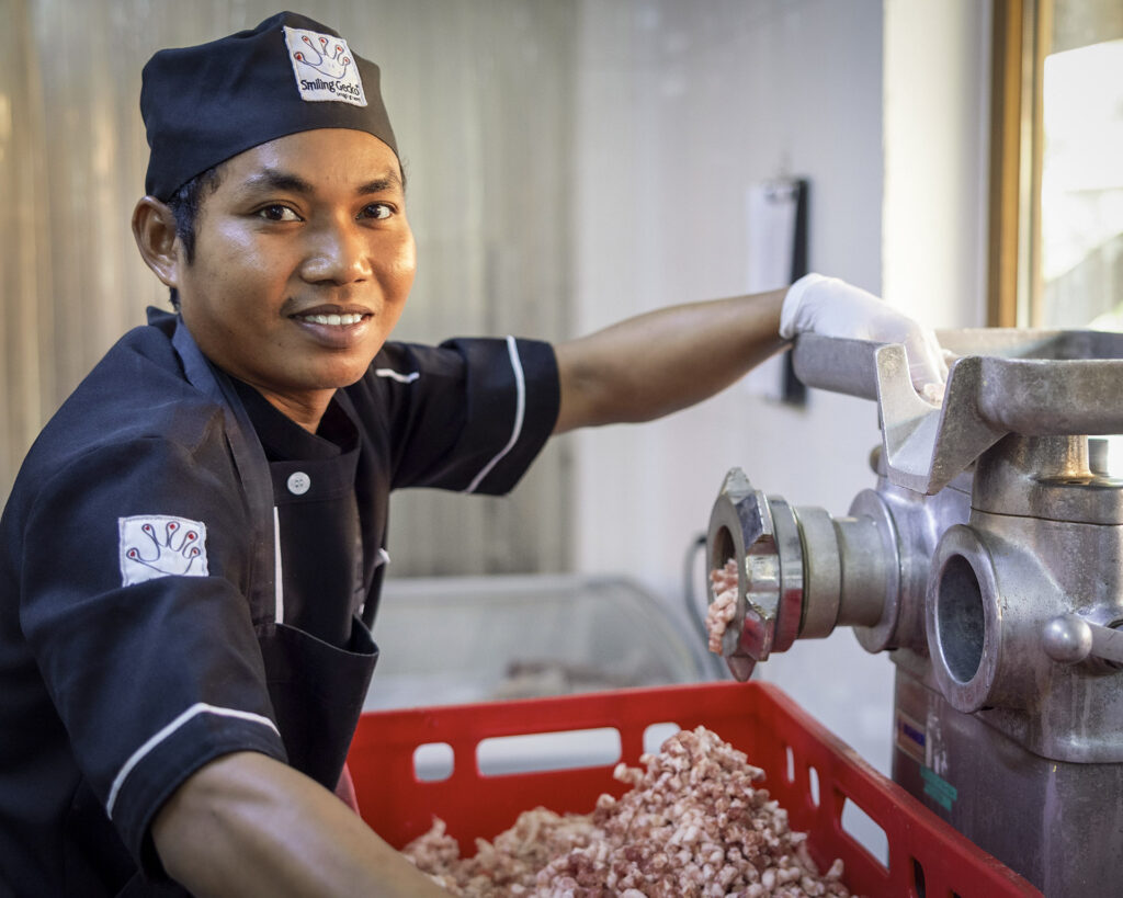 Staff member processing meat.