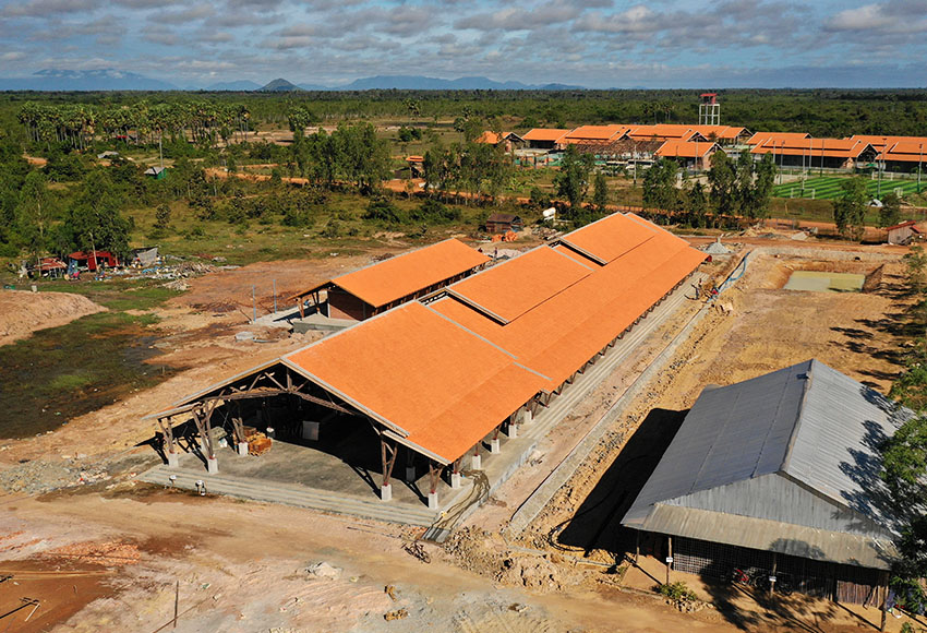 Aerial view of a long school building under construction.