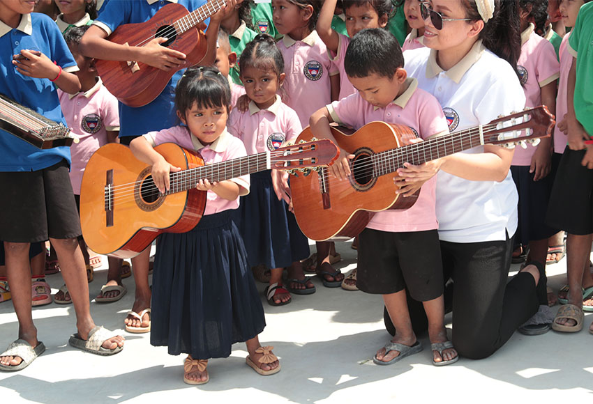 Schoolchildren playing guitars together.
