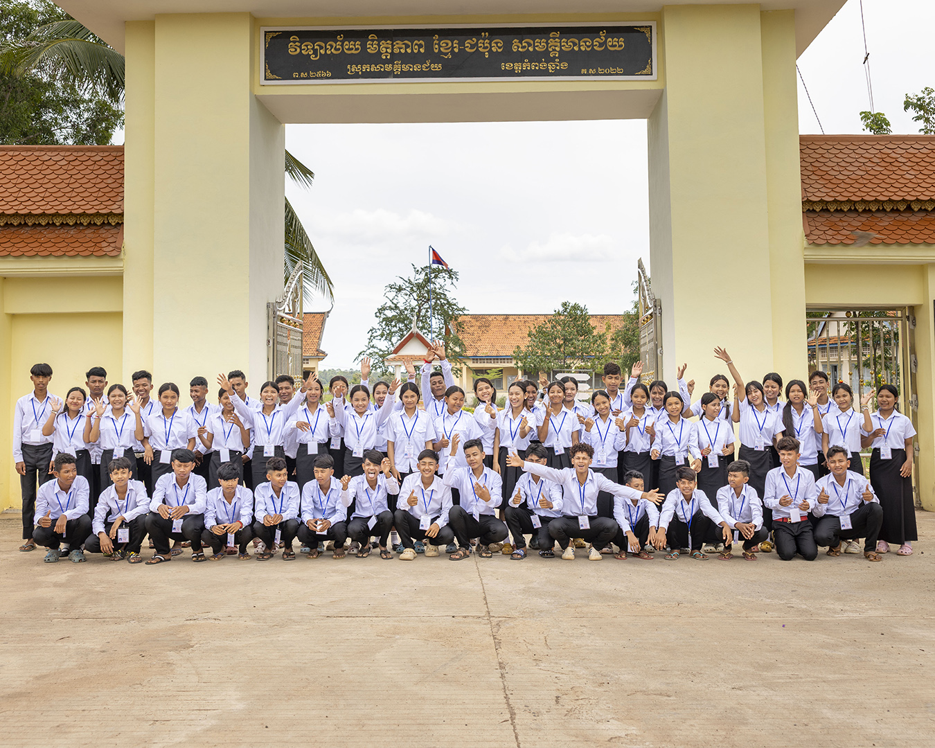 Class posing for a group photo outside a building.