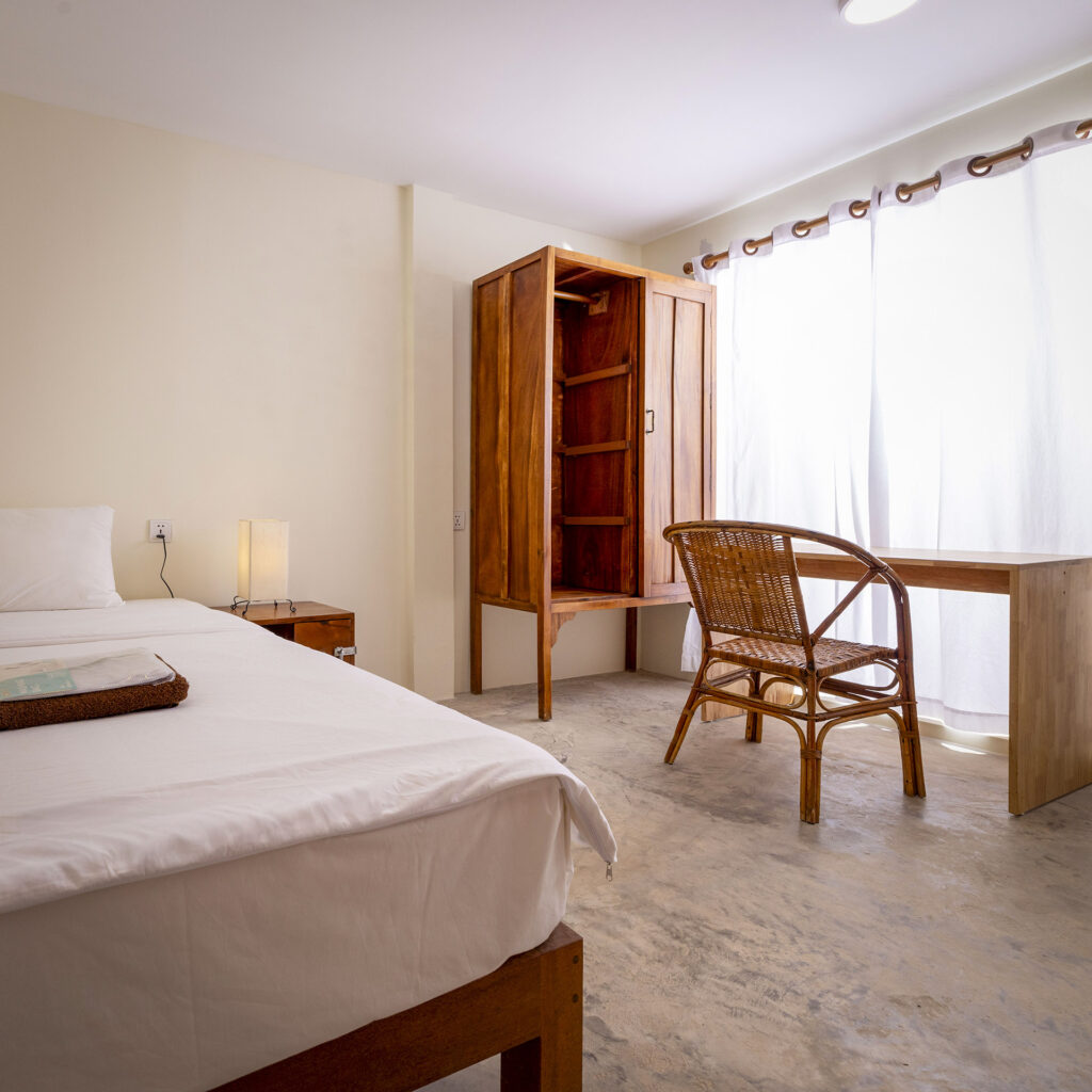 Bright guest room with a bed and desk.