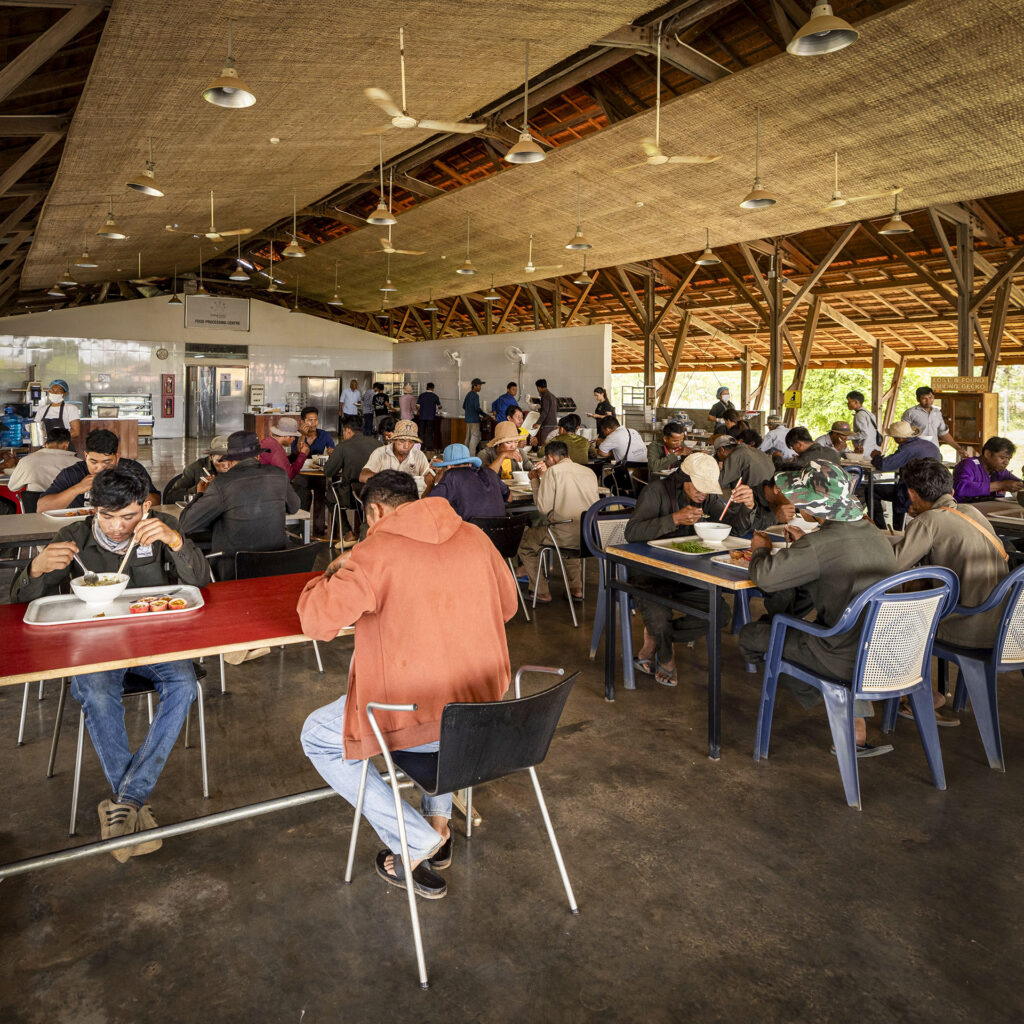 People sharing a meal in the open-sided canteen.