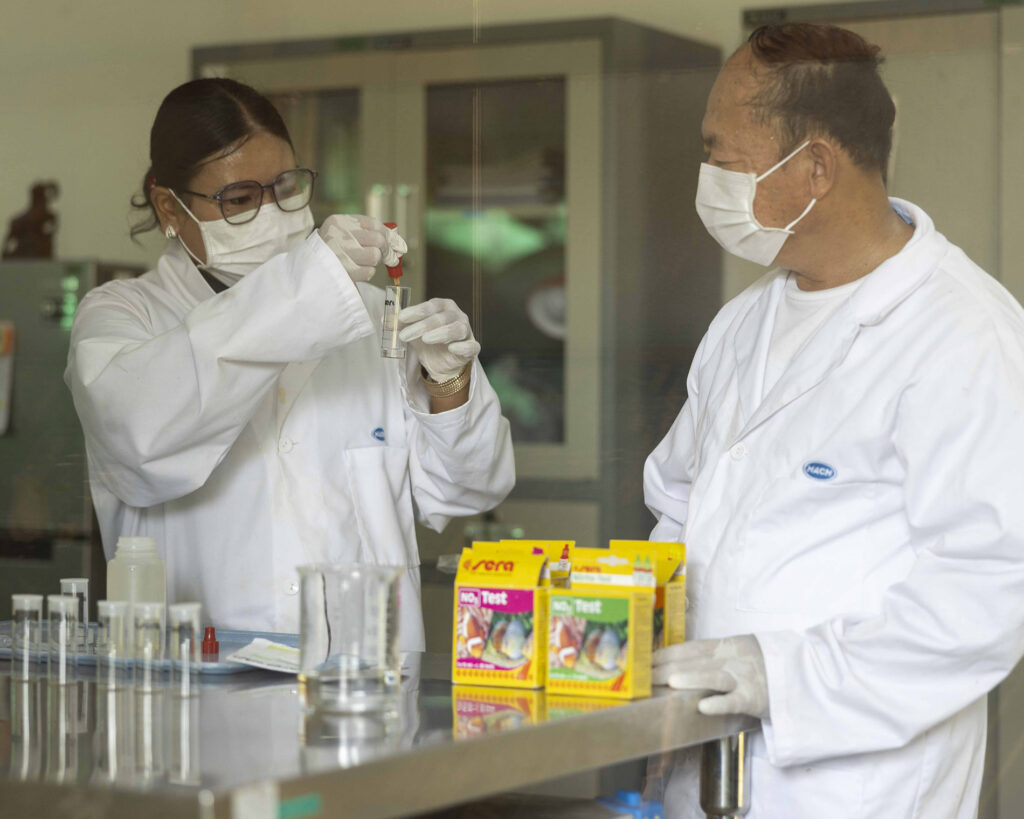 Deux personnes en tenue de protection travaillent dans un laboratoire.