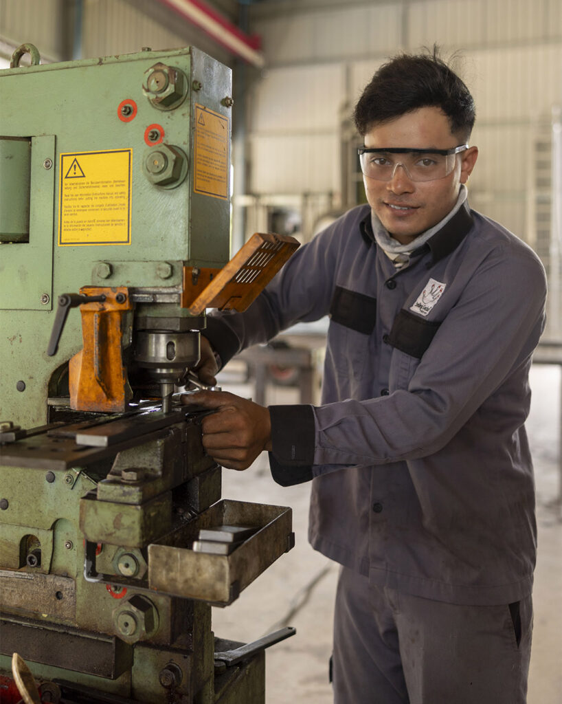 Mitarbeiter arbeitet an einer Maschine in der Metallwerkstatt.