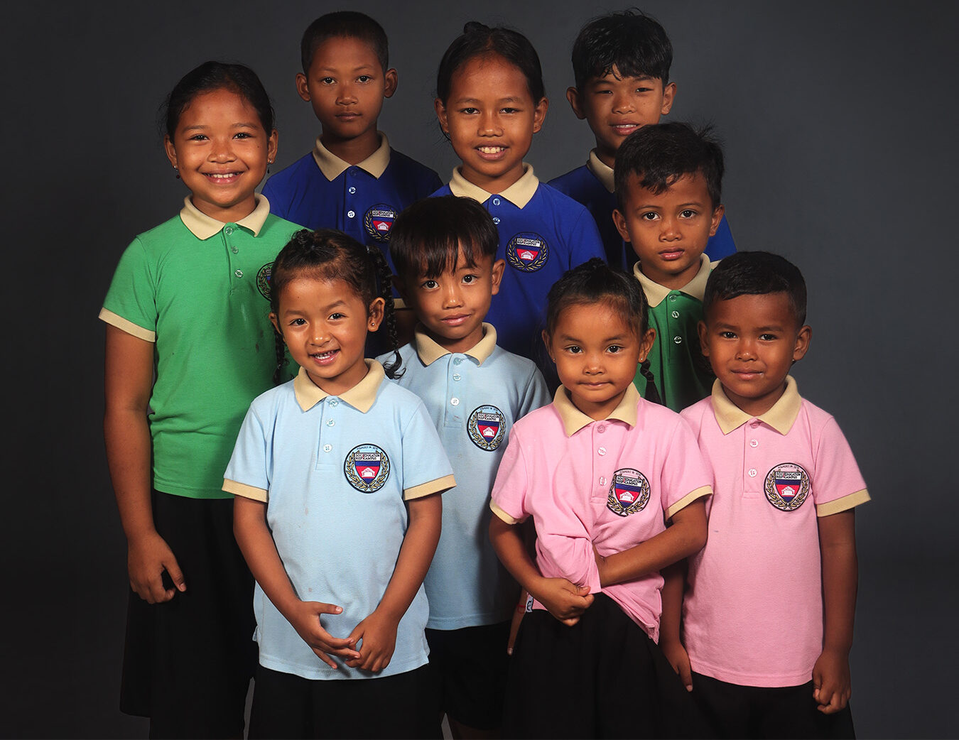 Un groupe d’élèves en polos scolaires de différentes couleurs.
